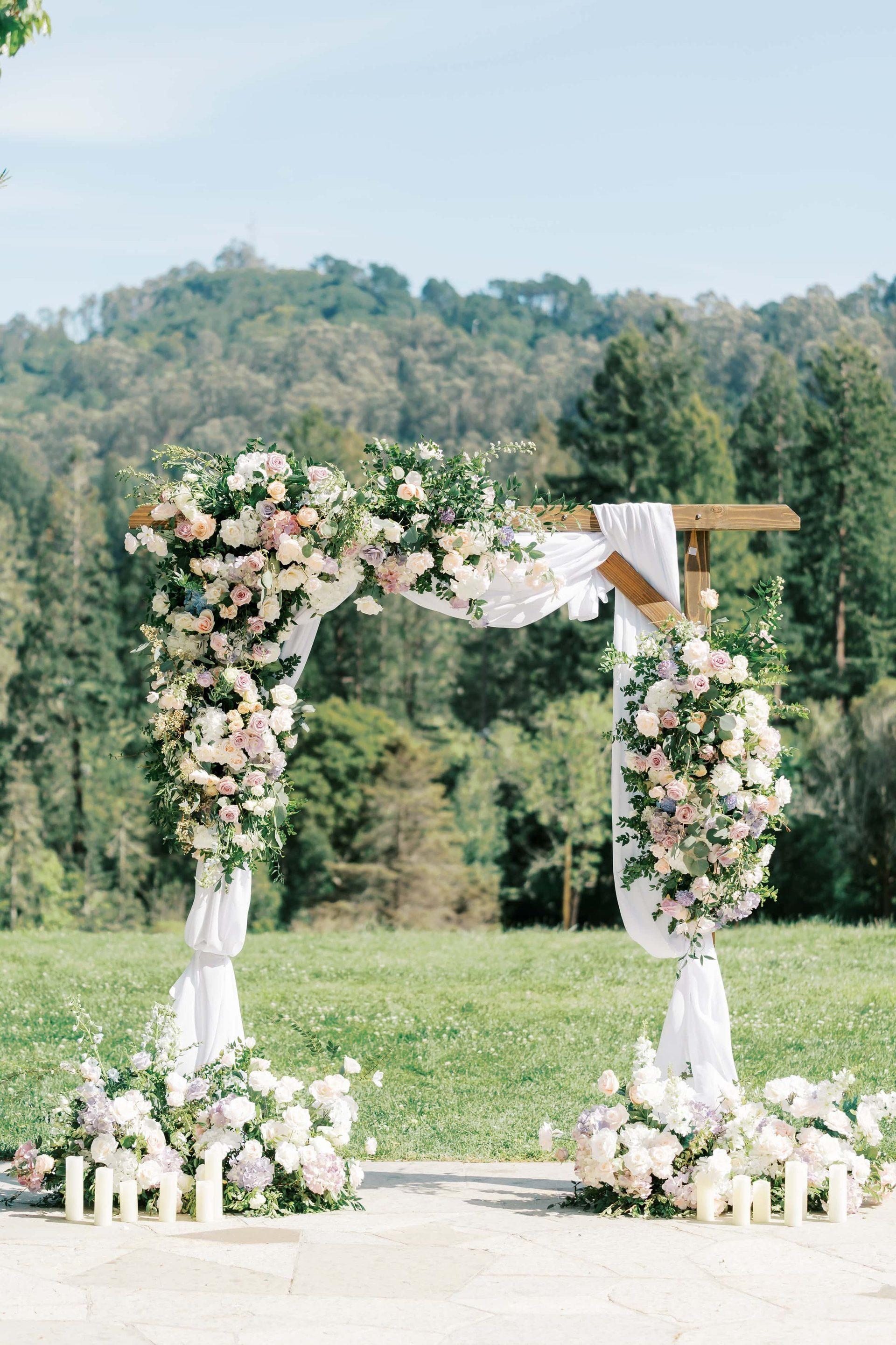 Tall wedding ceremony arch of white roses and greenery